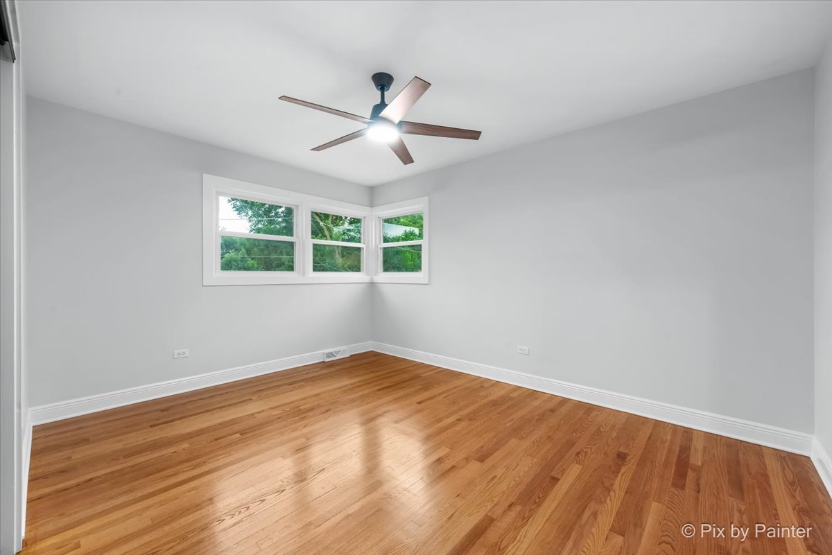 918 Delles Road Wheaton, IL 60189 - Photo 17 of 36 an empty room with wooden floor fan and windows