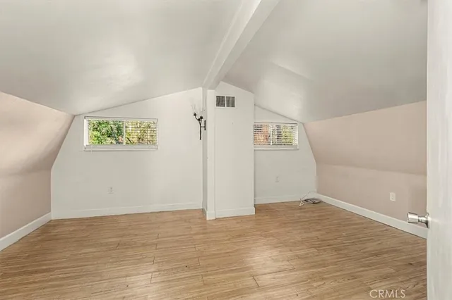 a view of empty room with wooden floor and fireplace