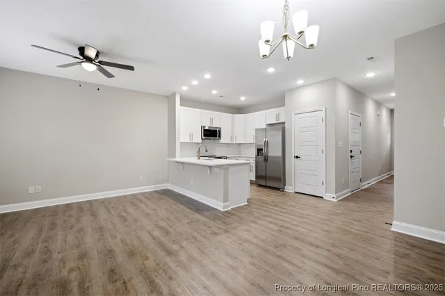 a view of a kitchen with a sink hardwood floor and a refrigerator
