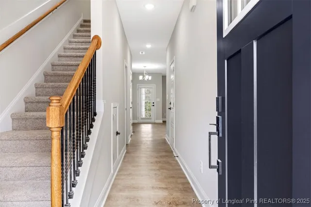 a view of a hallway with wooden floor and stairs