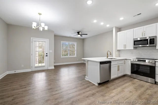 a kitchen with a refrigerator and a stove top oven