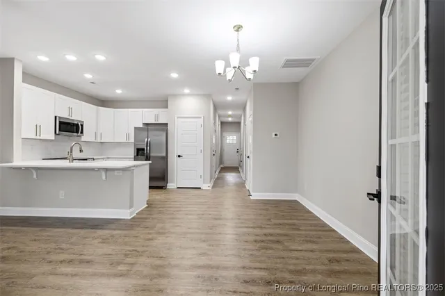 a view of kitchen with granite countertop cabinets and refrigerator
