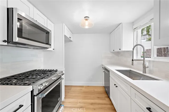 a kitchen with stainless steel appliances granite countertop a sink stove and microwave