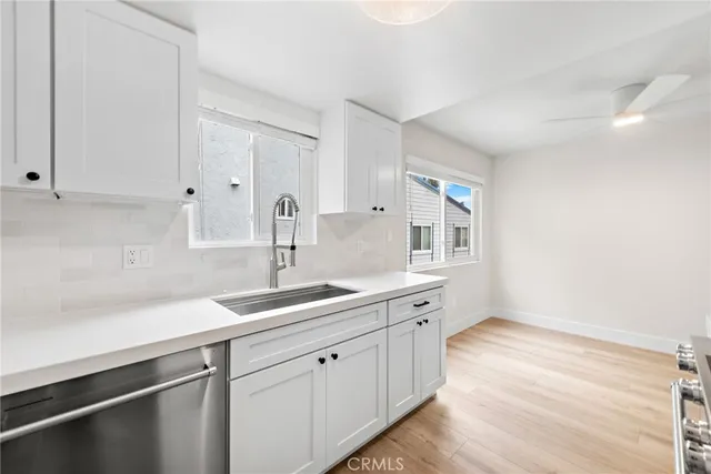 a kitchen with a sink cabinets and wooden floor