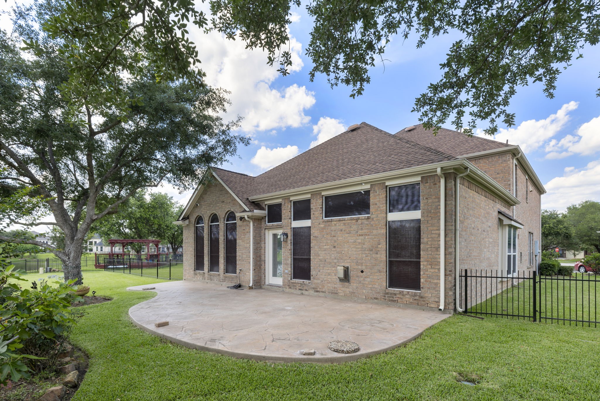 2907 Stemwood Drive Spring, TX 77388 - Photo 30 of 33 Extended stamped-concrete patio overlooks the spacious waterfront backyard, offering the perfect setting for outdoor dining, entertaining, or relaxing beneath mature shade trees with peaceful lake views.