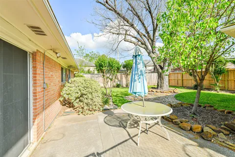 a view of a chair and table in backyard of the house