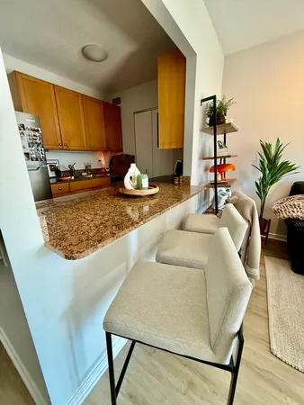 a living room with kitchen countertops and potted plant