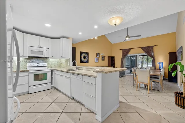 a kitchen with white cabinets and white appliances