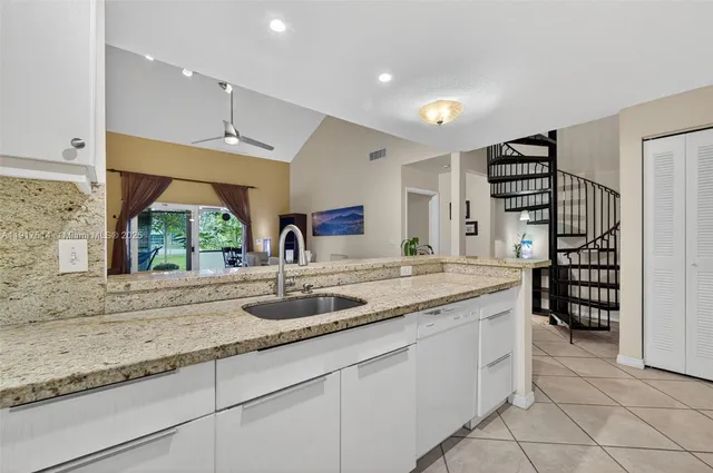 a kitchen with stainless steel appliances granite countertop a sink and a large window