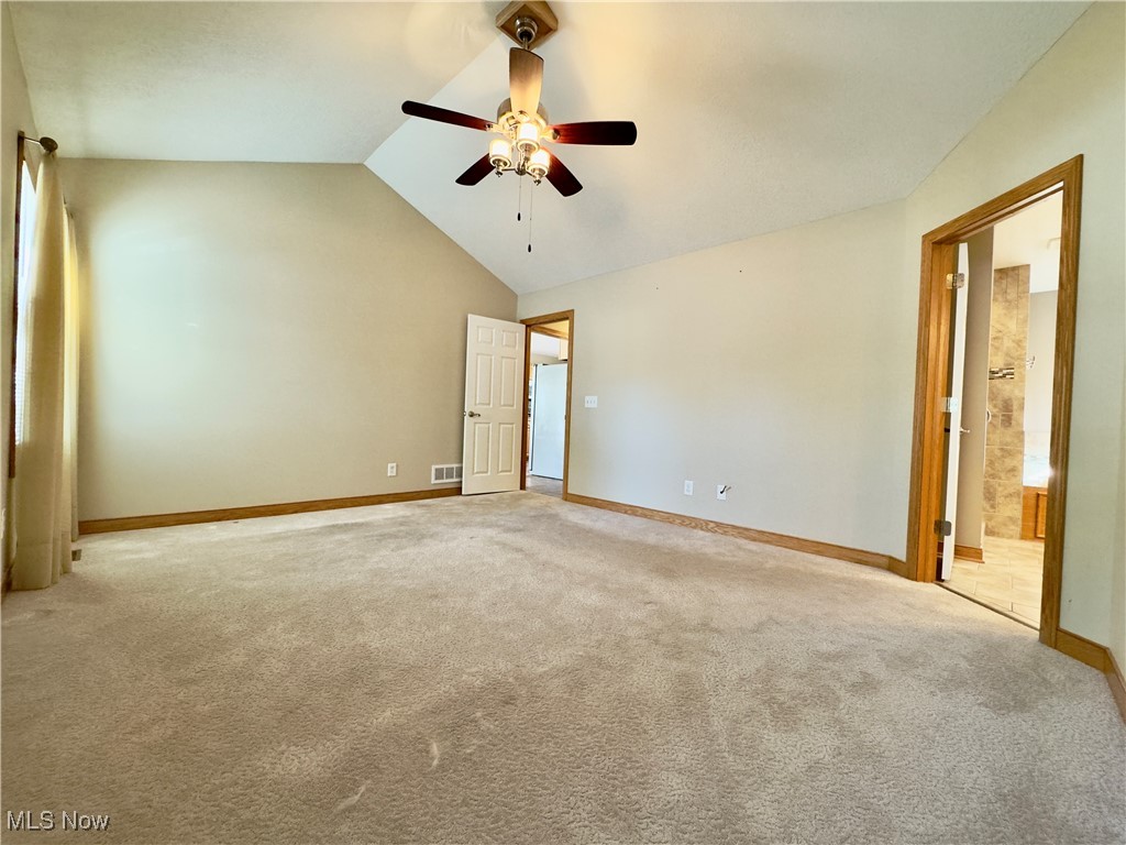 6014 Wentworth Road Southwest Canton, OH 44706 - Photo 10 of 22 Unfurnished primary bedroom with lofted ceiling, light carpet, ceiling fan, and ensuite bathroom