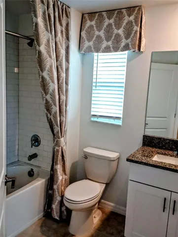 a white toilet sitting next to a bath tub