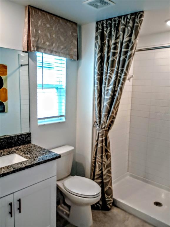 21415 Darter Road Land O' Lakes, FL 34638 - Photo 18 of 27 a bathroom with a granite countertop sink toilet and shower