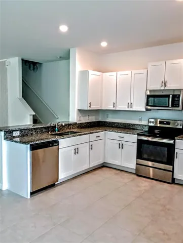 a large kitchen with stainless steel appliances granite countertop a stove and a sink