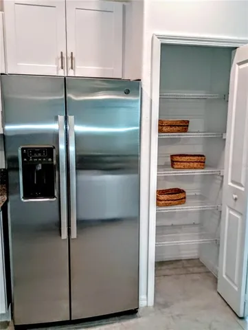 a kitchen with a refrigerator and a more cabinets