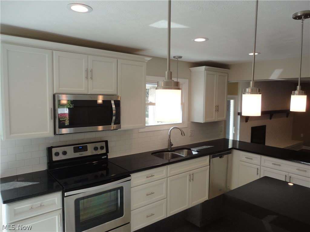 19646 Prospect Road Strongsville, OH 44149 - Photo 11 of 32 Modern lighting, s/s sink with garbage disposal and self closing cabinets adorn this large ( 24 X 15 eat-in kitchen. Half bath and laundry room located off the south side of kitchen to the left.