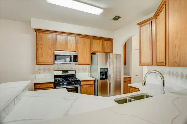 a kitchen with stainless steel appliances a refrigerator sink and cabinets