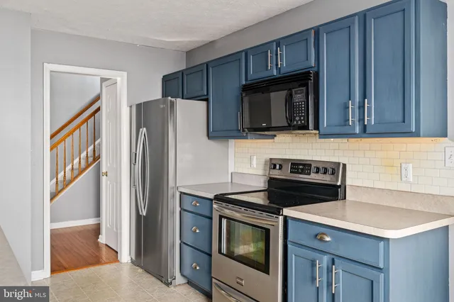a kitchen with stainless steel appliances granite countertop a refrigerator stove and microwave