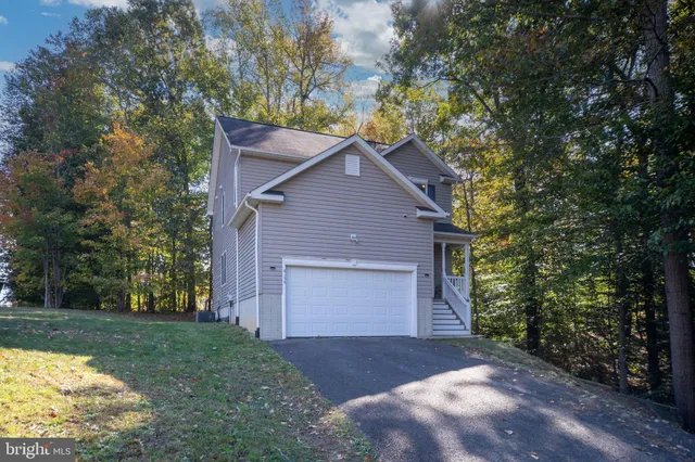 a front view of house with yard and trees in the background