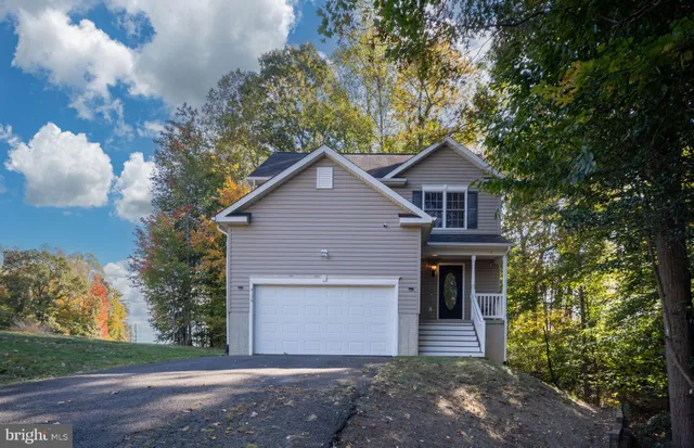 a front view of a house with a garden and trees