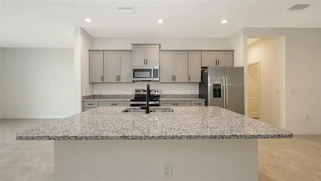 a kitchen with granite countertop a refrigerator and a sink