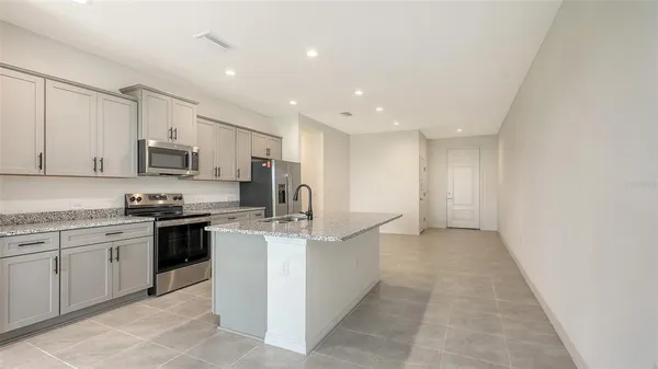 a kitchen with stainless steel appliances granite countertop a stove top oven a sink and dishwasher