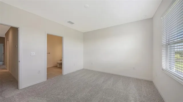 an empty room with windows and closet