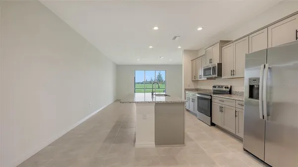 a kitchen with granite countertop white cabinets and stainless steel appliances