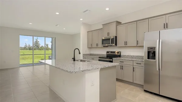 a kitchen with stainless steel appliances granite countertop a refrigerator sink and stove