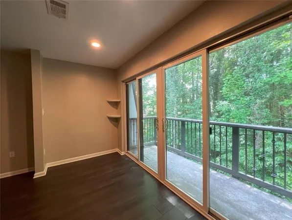 a view of empty room with wooden floor and floor to ceiling window