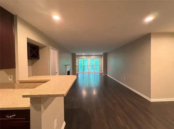a view of a kitchen with wooden floor and a window