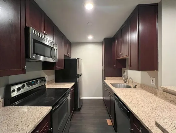 a kitchen with stainless steel appliances granite countertop a sink stove and microwave