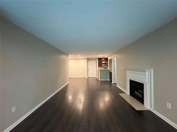 a view of a livingroom with wooden floor and a fireplace