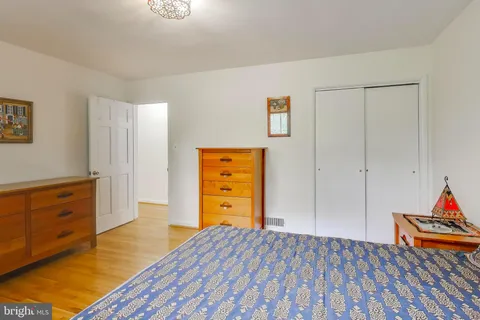 a view of a bedroom with wooden floor and dresser