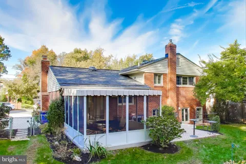 a view of a house with brick walls and a yard with plants