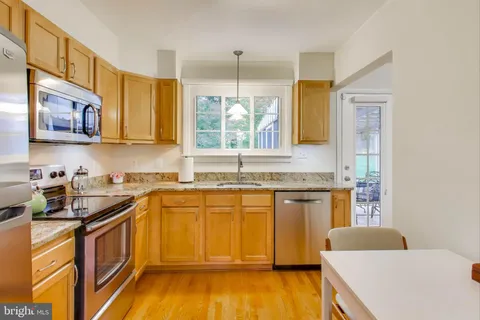 a kitchen with a sink a window and cabinets
