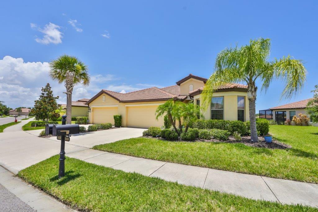 a front view of a house with a yard and potted plants