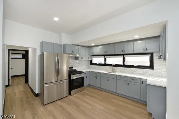 a kitchen with granite countertop a refrigerator and a sink