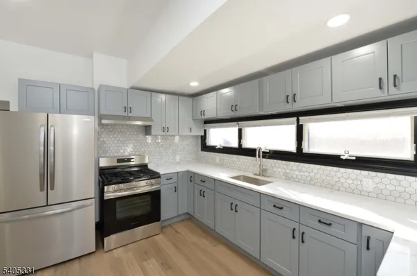 a kitchen with granite countertop white cabinets and stainless steel appliances