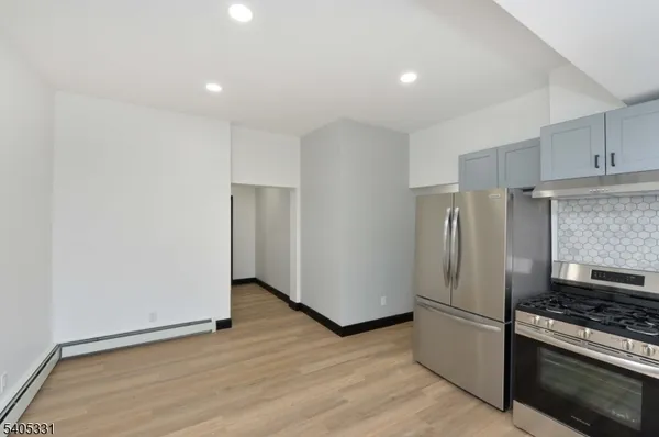 a kitchen with a refrigerator and a stove top oven