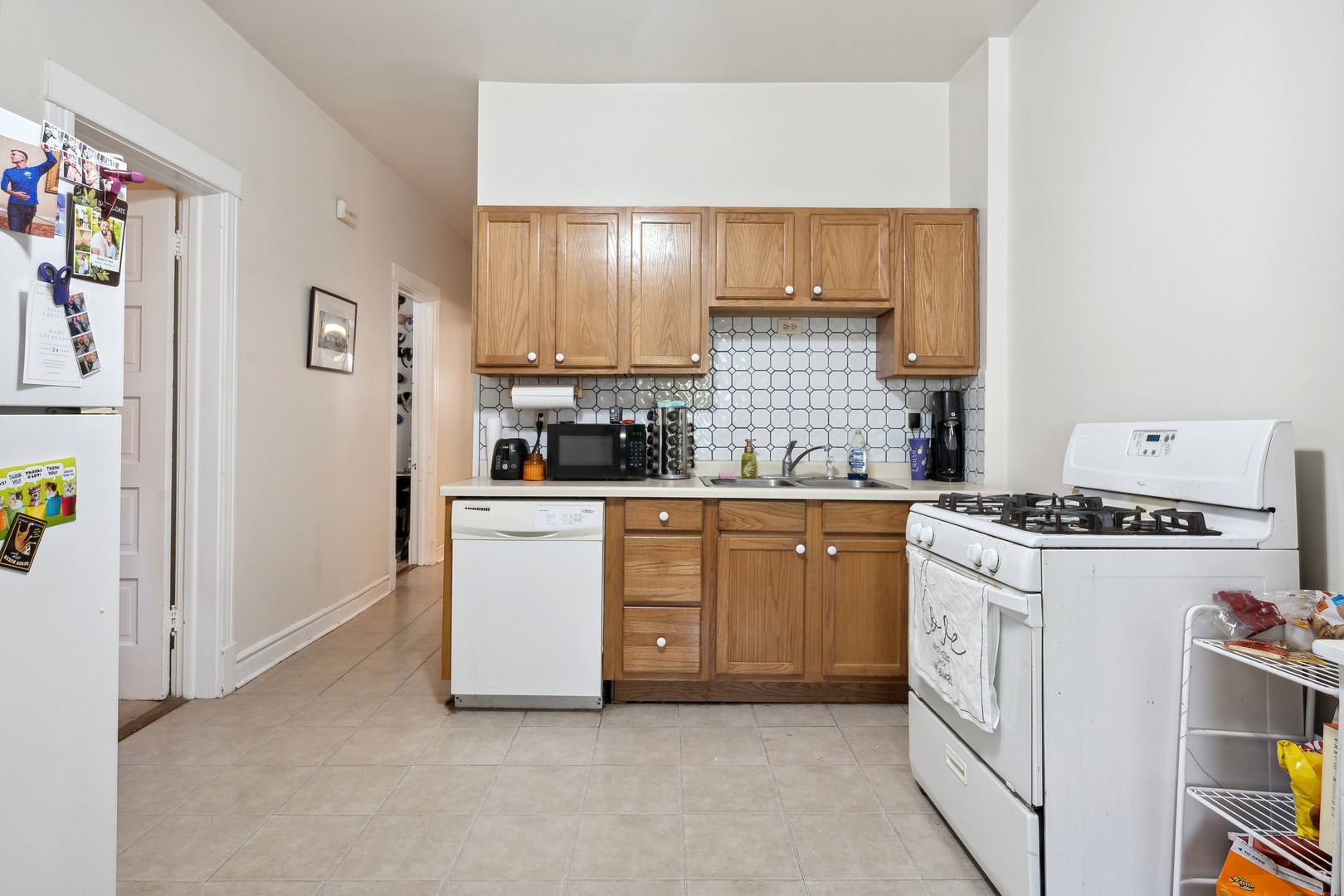 3837 North Lakewood Avenue Chicago, IL 60613 - Photo 13 of 19 a kitchen with white cabinets and white appliances