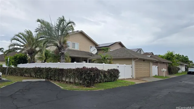 a front view of a house with a garden and plants