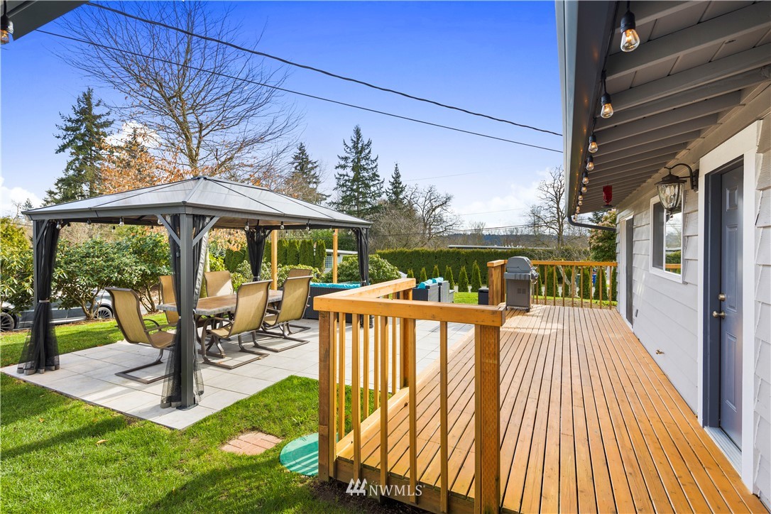33 243rd Place Southeast Bothell, WA 98021 - Photo 19 of 28 a view of a patio with table and chairs potted plants with wooden floor and floor to ceiling window