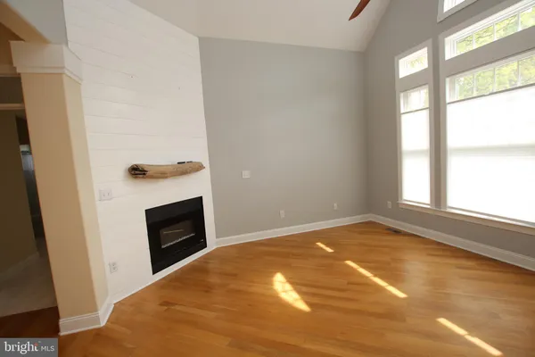 a view of empty room with floor to ceiling window and fireplace