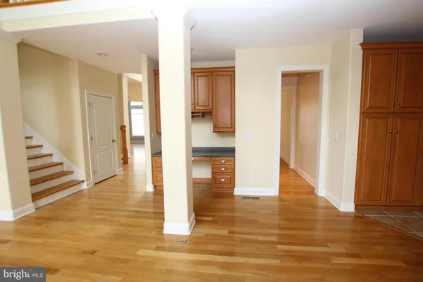 a view of a hallway with wooden floor and staircase
