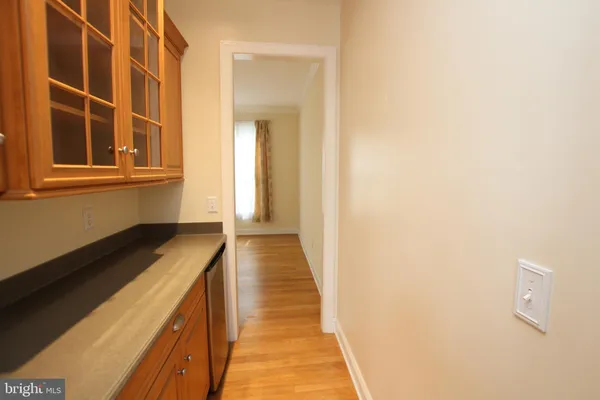 a hallway with wooden floor and cabinet