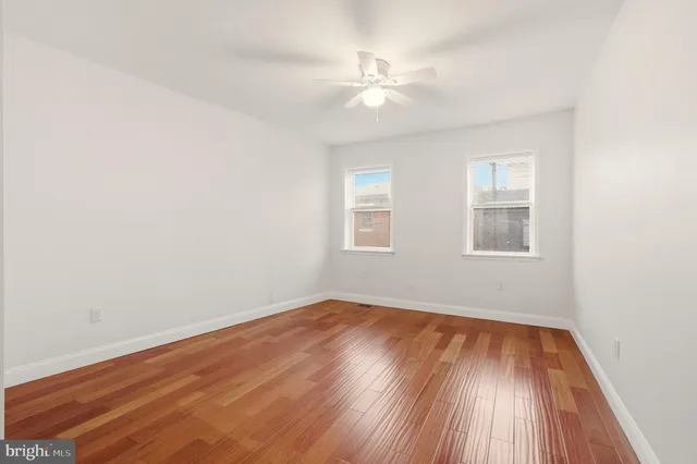 a view of a big room with wooden floor and windows