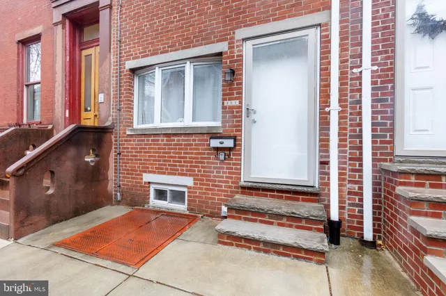 a backyard of a house with barbeque oven and wooden fence