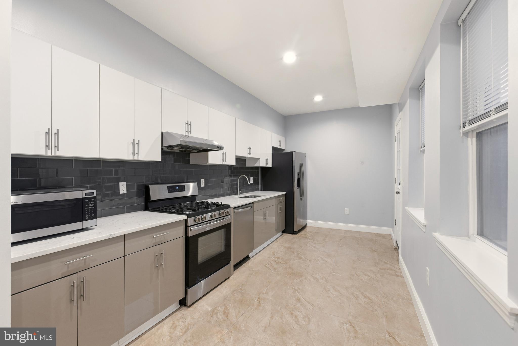 909 North 4th Street Philadelphia, PA 19123 - Photo 5 of 24 a kitchen with stainless steel appliances granite countertop a stove a sink and a refrigerator