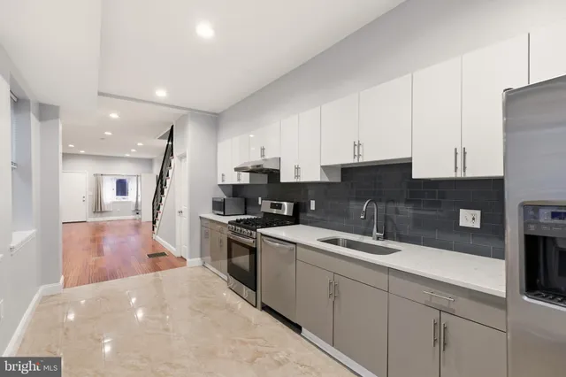 a kitchen with stainless steel appliances granite countertop a refrigerator and a sink