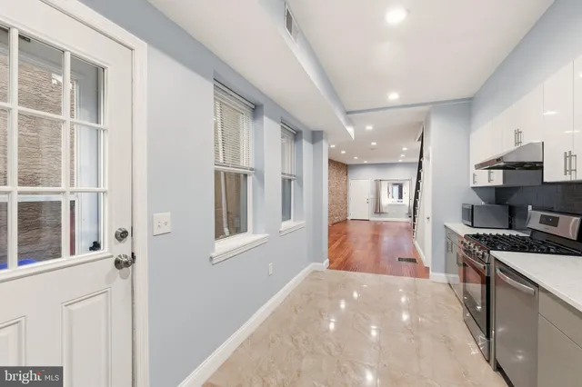 a view of an empty room and stairs with wooden floor